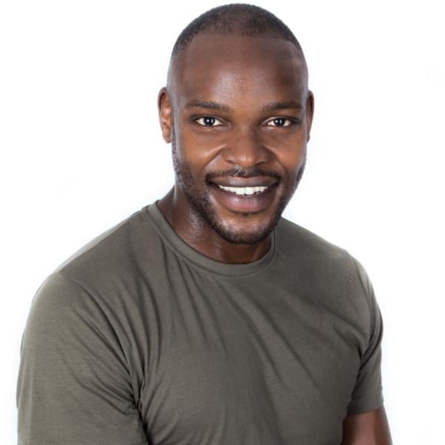 Smiling man wearing olive green t-shirt, headshot portrait against white background